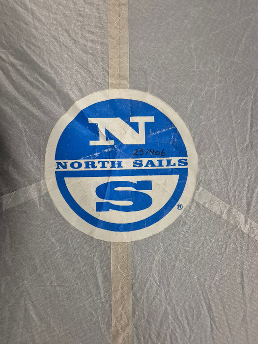 Round blue and white logo with 'North Sails' text on a textured gray background