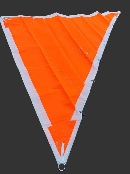An orange triangular storm jib sail with  bronze Swedish piston hanks 
